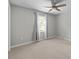 Neutral bedroom showcasing a window, light gray walls, neutral carpet, ceiling fan and light-blocking gray curtains at 9319 Harps Mill Ct, Charlotte, NC 28270