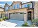 Beautiful stone-accented townhome with an attached two-car garage, manicured landscaping and an arched entryway at 9551 Glenburn Ln, Charlotte, NC 28278