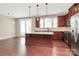 Open-concept kitchen showcasing a center island bar, stainless steel appliances, and hardwood floors at 9551 Glenburn Ln, Charlotte, NC 28278