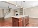 Open-concept kitchen with island bar overlooking the staircase, living room, and fireplace at 9551 Glenburn Ln, Charlotte, NC 28278