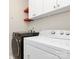 Modern laundry room features side-by-side washer and dryer with overhead storage and a convenient layout at 9551 Glenburn Ln, Charlotte, NC 28278