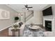 Bright living room with a fireplace, staircase, ceiling fan, hardwood floors, and modern decor at 9551 Glenburn Ln, Charlotte, NC 28278