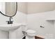 Modern powder room with a pedestal sink, toilet, and wainscoting at 9551 Glenburn Ln, Charlotte, NC 28278