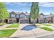 Eye-level street view of newly constructed townhomes with manicured lawns and tree-lined driveways at 9551 Glenburn Ln, Charlotte, NC 28278