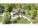 Stunning aerial view of an estate home with lush landscaping and a circular driveway nestled among mature trees at 1012 Shippon Ln, Waxhaw, NC 28173