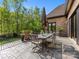 Outdoor patio with table and chairs, brick wall, and views of the backyard and blue sky at 1012 Shippon Ln, Waxhaw, NC 28173