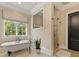 Spa-like bathroom features a soaking tub, walk-in shower, and scenic outdoor view at 1012 Shippon Ln, Waxhaw, NC 28173