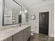 Modern bathroom featuring a granite vanity, a large mirror, and a walk-in shower visible in the mirror at 1012 Shippon Ln, Waxhaw, NC 28173
