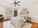 Cozy bedroom with hardwood floors, a queen bed, and natural light from the large window at 1012 Shippon Ln, Waxhaw, NC 28173