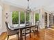 Bright dining room with a view of the wooded landscape through large windows and modern chandelier at 1012 Shippon Ln, Waxhaw, NC 28173