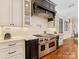 Close up view of a kitchen featuring a stainless steel Wolf oven, custom cabinetry, and hardwood floors at 1012 Shippon Ln, Waxhaw, NC 28173