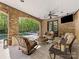 A covered patio features stone accents, comfortable seating, and views of the pool and backyard at 1012 Shippon Ln, Waxhaw, NC 28173