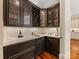 Stylish wet bar with dark cabinetry, wine rack, and countertop sink at 1012 Shippon Ln, Waxhaw, NC 28173