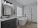 Relaxing bathroom with soaking tub, modern vanity, and stylish fixtures at 116 Jim Parker Rd, Wesley Chapel, NC 28110