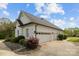 Charming brick home exterior boasts a three-car garage, well-manicured landscaping, and blue skies at 116 Jim Parker Rd, Wesley Chapel, NC 28110