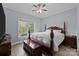 A naturally lit main bedroom features a wooden four-poster bed, a ceiling fan, and a chest at 116 Jim Parker Rd, Wesley Chapel, NC 28110