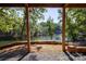 Covered back porch with lake view surrounded by lush green trees at 119 Harbor Ln, Mount Gilead, NC 27306