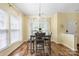 Bright dining area featuring hardwood floors, a stylish light fixture, and a table set for four, filled with natural light at 121 Talbert Town Loop, Mooresville, NC 28117
