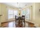 Cozy dining space with warm wood flooring, a modern light fixture, and ample natural light streaming through the windows at 121 Talbert Town Loop, Mooresville, NC 28117