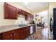 Well-lit kitchen featuring stainless steel appliances, dark wood cabinetry, and hardwood flooring at 121 Talbert Town Loop, Mooresville, NC 28117