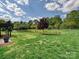 Backyard with lush green grass, a pond with a fountain, and beautiful trees at 1231 Restoration Dr, Marvin, NC 28173