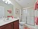 Bathroom featuring a sink, vanity, toilet, and a glass-enclosed shower, with peach colored accents at 1231 Restoration Dr, Marvin, NC 28173
