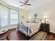 The bedroom includes a wrought iron bed, a ceiling fan, and hardwood floors at 1231 Restoration Dr, Marvin, NC 28173