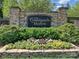Stone community sign for The Courtyards at Marvin with manicured landscaping and flowerbeds at 1231 Restoration Dr, Marvin, NC 28173