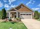 Charming home with a two-car garage, stone accents, well-maintained landscaping, and an inviting front porch at 1231 Restoration Dr, Marvin, NC 28173