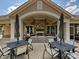 Inviting outdoor fireplace on the patio featuring comfortable seating, dining tables, and shade umbrellas at 1231 Restoration Dr, Marvin, NC 28173