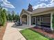 Outdoor patio with seating and dining areas, screened in porch, fireplace, and landscaped surroundings at 1231 Restoration Dr, Marvin, NC 28173