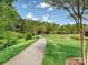 Community walking path surrounded by lush greenery, mature trees and a pond at 1231 Restoration Dr, Marvin, NC 28173