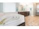 Bright bathroom featuring a soaking tub and a double sink vanity with a large mirror at 126 Pointer Se Ct, Concord, NC 28025