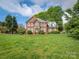 Traditional two-story brick home with a well-manicured front lawn and mature trees at 126 Pointer Se Ct, Concord, NC 28025