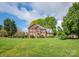 Traditional two-story brick home with a well-manicured front lawn and mature trees at 126 Pointer Se Ct, Concord, NC 28025