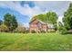 Traditional two-story brick home with a well-manicured front lawn and mature trees at 126 Pointer Se Ct, Concord, NC 28025