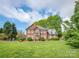Stunning brick home with well-manicured front lawn and mature trees, offering classic elegance and curb appeal at 126 Pointer Se Ct, Concord, NC 28025