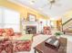 Cozy living room with a classic fireplace, floral furniture, and a view into the adjacent dining area at 126 Pointer Se Ct, Concord, NC 28025