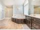 Elegant main bathroom with a jacuzzi tub, walk-in shower, dual sink vanity, and tiled flooring at 126 Pointer Se Ct, Concord, NC 28025