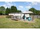 Backyard features a deck with pergola, hot tub, fire pit, grill, flowering bushes, and a fenced-in lawn at 140 Misty Ln, Rockwell, NC 28138