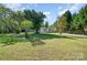 Expansive front yard with mature trees offering shade and privacy at 140 Misty Ln, Rockwell, NC 28138