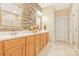 Bathroom with double sinks, stone accent wall, tiled floors, and glass shower at 1427 Doe Ridge Ln, Fort Mill, SC 29715