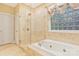 Bathroom with a soaking tub, glass enclosed shower and decorative window at 1427 Doe Ridge Ln, Fort Mill, SC 29715
