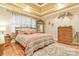Bedroom featuring a comfortable bed, wooden furniture and a tray ceiling at 1427 Doe Ridge Ln, Fort Mill, SC 29715