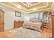 Cozy bedroom with a tray ceiling, a comfortable bed, and wooden furniture at 1427 Doe Ridge Ln, Fort Mill, SC 29715