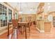 Dining room with a view into the kitchen, a large light fixture, and warm wooden floors at 1427 Doe Ridge Ln, Fort Mill, SC 29715