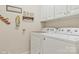 Clean laundry room with a white washer and dryer set and ample cabinet space for storage at 1427 Doe Ridge Ln, Fort Mill, SC 29715