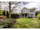 This large backyard features green grass, a swing set, a screened porch, mature landscaping and trees at 1550 Matthew Mcclure Cir, Davidson, NC 28036