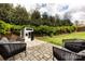 Spacious backyard with green grass, a small playhouse, mature trees, and comfortable lounge chairs at 1550 Matthew Mcclure Cir, Davidson, NC 28036