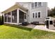 This backyard features a playhouse, a screened porch, a patio with furniture, and a lush lawn at 1550 Matthew Mcclure Cir, Davidson, NC 28036